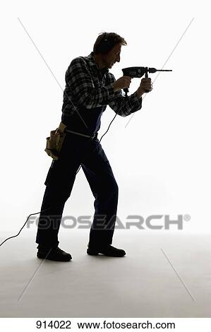 Stock Image - A construction worker using a drill. Fotosearch