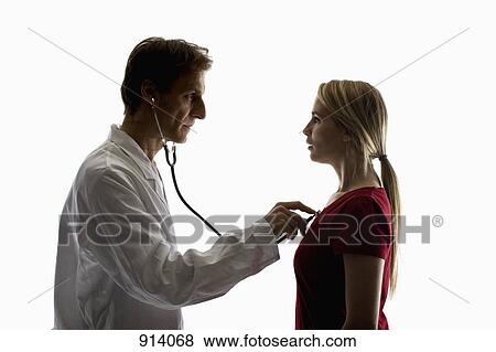 Stock Photo - A doctor using a stethoscope performing an exam on a patient . Fotosearch