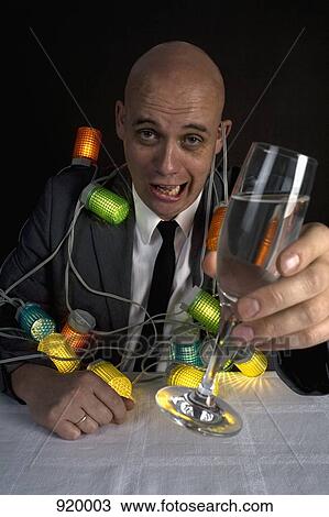 A drunk man with a string of lights around him holding a glass of champagne View Large Photo Image Stock Image - A drunk man with a string of lights around him holding a glass of champagne. Fotosearch