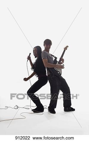 A female singer and a man playing electric guitar, studio shot, white background, back lit View Large Photo Image Stock Image - A female singer and a man playing electric guitar, studio shot, white background, back lit. Fotosearch