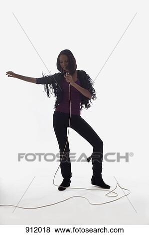 A female singer performing, studio shot, white background, back lit View Large Photo Image Stock Photo - A female singer performing, studio shot, white background, back lit. Fotosearch