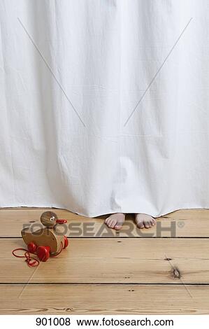 A hiding child's feet sticking out from under a hanging sheet View Large Photo Image Stock Photo - A hiding child's feet sticking out from under a hanging sheet. Fotosearch