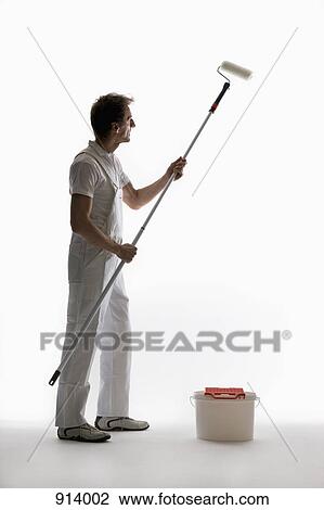Stock Image - A house painter using a paint roller. Fotosearch