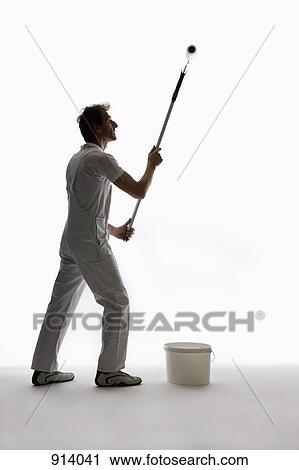 Stock Image - A house painter using a paint roller. Fotosearch