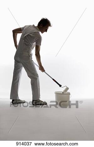 Stock Photo - A house painter using a paint roller. Fotosearch