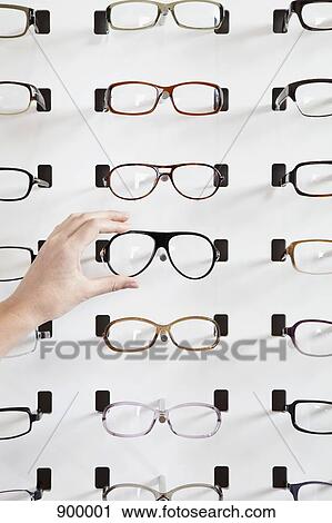 A human hand choosing a pair of glasses in an eyewear store View Large Photo Image Stock Image - A human hand choosing a pair of glasses in an eyewear store. Fotosearch