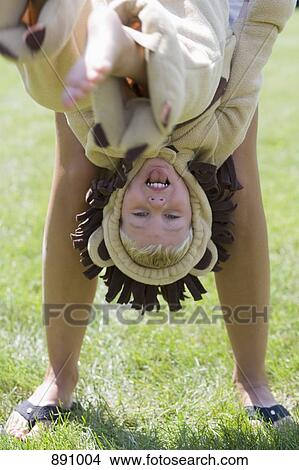 A little boy in a lion costume being held upside down by an adult View Large Photo Image Picture - A little boy in a lion costume being held upside down by an adult. Fotosearch