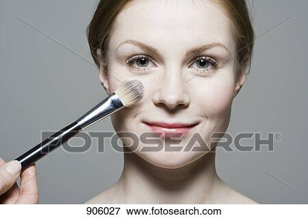 Stock Photo - A make-up artist applying blush. Fotosearch