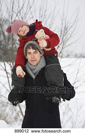 Stock Image - A man carrying his daughter on his shoulders. Fotosearch