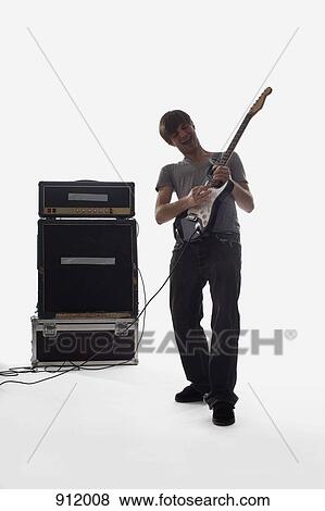 A man playing an electric guitar, studio shot, white background, back lit View Large Photo Image Stock Photo - A man playing an electric guitar, studio shot, white background, back lit. Fotosearch