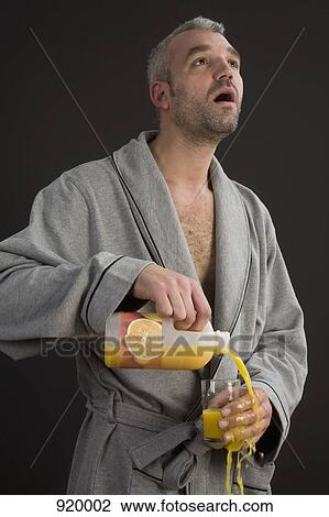 A man pouring orange juice into a glass and spilling it View Large Photo Image Stock Image - A man pouring orange juice into a glass and spilling it. Fotosearch