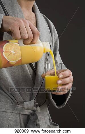 A man pouring orange juice into a glass, midsection View Large Photo Image Stock Photo - A man pouring orange juice into a glass, midsection. Fotosearch