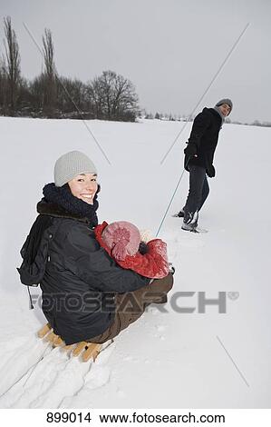 A man pulling a sled with his wife and daughter on it View Large Photo Image Picture - A man pulling a sled with his wife and daughter on it. Fotosearch