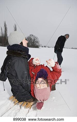 A man pulling a sled with his wife and daughter on it View Large Photo Image Stock Photo - A man pulling a sled with his wife and daughter on it. Fotosearch