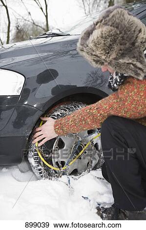 A man putting snow chains on his tires View Large Photo Image Stock Photo - A man putting snow chains on his tires. Fotosearch