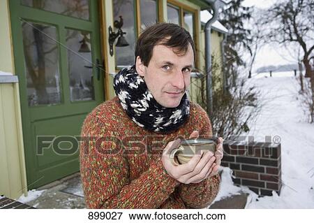 A man sitting on the front stoop of a house holding a hot drink View Large Photo Image Stock Photo - A man sitting on the front stoop of a house holding a hot drink. Fotosearch