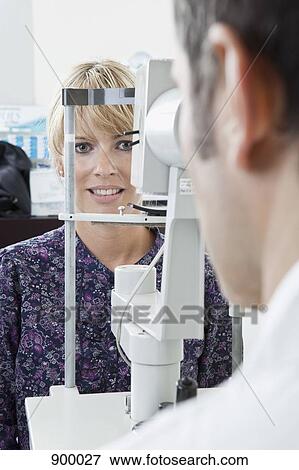 Stock Photo - A patient being examined with a slit-lamp biomicroscope by an ophthalmologist. Fotosearch