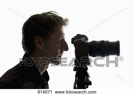 Stock Image - A photographer working with a camera on a tripod. Fotosearch