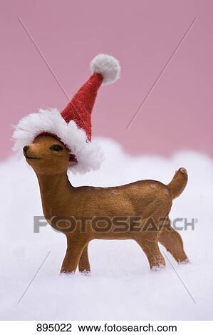 Stock Image - A reindeer figurine standing in fake snow. Fotosearch