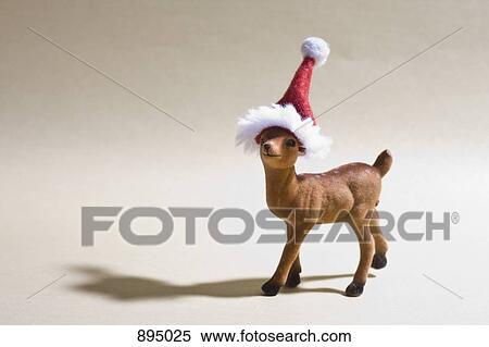 A reindeer figurine wearing a Santa hat View Large Photo Image Stock Photography - A reindeer figurine wearing a Santa hat. Fotosearch