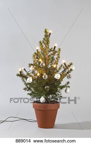 A small Christmas tree decorated with lights and baubles View Large Photo Image Picture - A small Christmas tree decorated with lights and baubles . Fotosearch