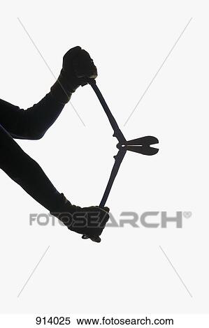 Stock Photography - A thief holding bolt cutters, focus on hands. Fotosearch