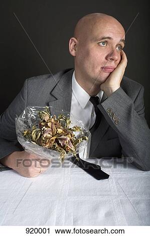 A well-dressed man holding a bouquet of dead flowers and looking sad View Large Photo Image Stock Image - A well-dressed man holding a bouquet of dead flowers and looking sad. Fotosearch