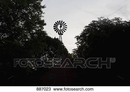 A windmill in front of a wooden house View Large Photo Image Stock Image - A windmill in front of a wooden house. Fotosearch