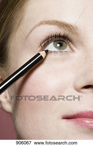 A woman applying eyeliner, detail of eye View Large Photo Image Stock Photo - A woman applying eyeliner, detail of eye. Fotosearch
