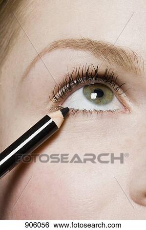 Stock Photograph - A woman applying eyeliner, detail of eye. Fotosearch