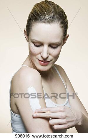 A woman applying lotion to her arm View Large Photo Image Stock Photograph - A woman applying lotion to her arm. Fotosearch