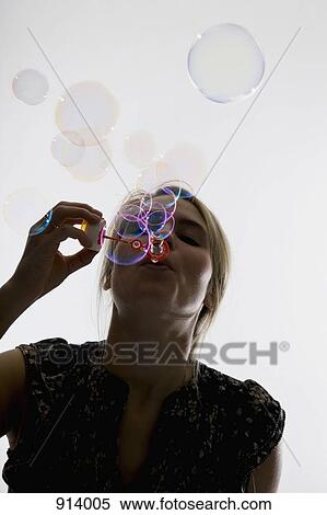 A woman blowing bubbles with a bubble wand View Large Photo Image Stock Photography - A woman blowing bubbles with a bubble wand. Fotosearch
