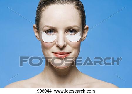 A woman doing an eye treatment  View Large Photo Image Picture - A woman doing an eye treatment . Fotosearch