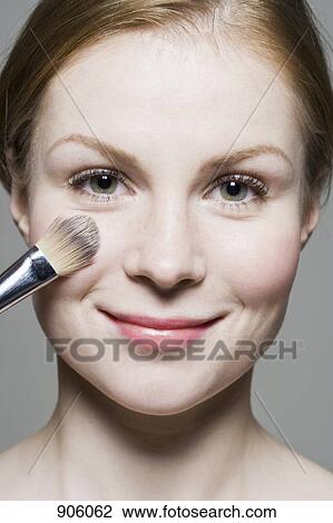 A woman having blush applied to her face View Large Photo Image Stock Image - A woman having blush applied to her face. Fotosearch