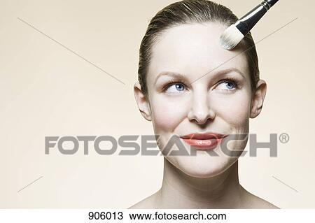 A woman having face powder applied to her face View Large Photo Image Stock Image - A woman having face powder applied to her face. Fotosearch