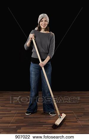 Stock Image - A Woman Holding A Broom. Fotosearch