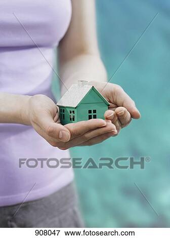 A woman holding a small house in cupped hands, focus on the hands View Large Photo Image Stock Photo - A woman holding a small house in cupped hands, focus on the hands. Fotosearch