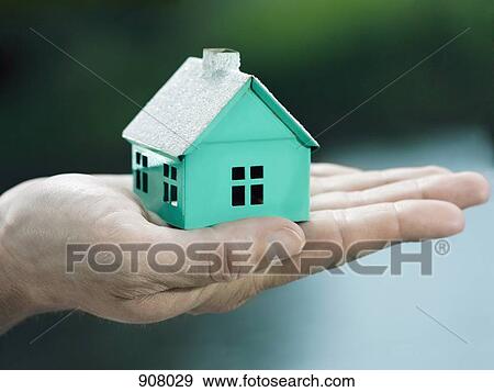 A woman holding a small house on her palm, focus on the hand View Large Photo Image Stock Photo - A woman holding a small house on her palm, focus on the hand. Fotosearch