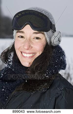 Stock Image - A woman outdoors in winter, head and shoulders, portrait. Fotosearch