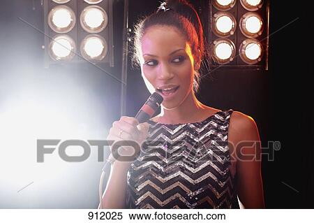 Stock Photography - A woman singer performing on stage. Fotosearch