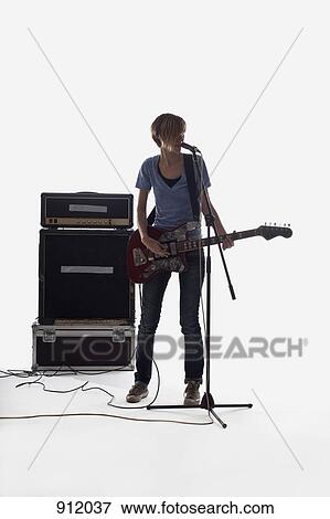 A woman singing and playing the electric guitar, studio shot, white background, back lit View Large Photo Image Stock Photo - A woman singing and playing the electric guitar, studio shot, white background, back lit. Fotosearch