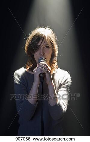 A Woman Standing Behind A Microphone View Large Photo Image Stock Photograph - A Woman Standing Behind A Microphone. Fotosearch