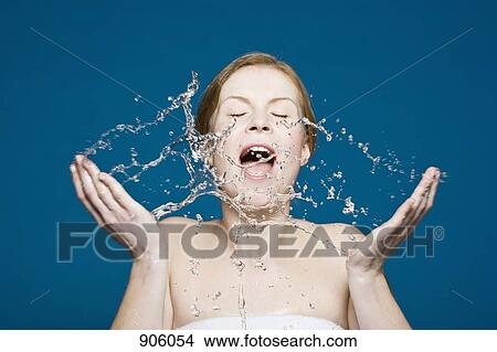 Picture - A woman washing her face. Fotosearch