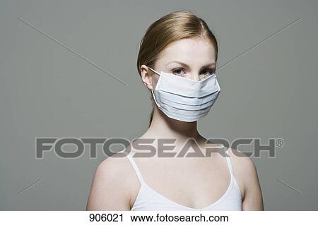 A woman wearing a protective surgical mask View Large Photo Image Stock Image - A woman wearing a protective surgical mask. Fotosearch