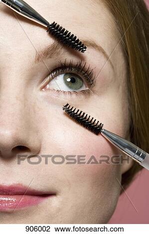 A woman with two mascara wands, extreme close up of face View Large Photo Image Stock Image - A woman with two mascara wands, extreme close up of face. Fotosearch