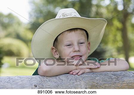 Stock Photograph - A young boy wearing a cowboy hat and smiling. Fotosearch