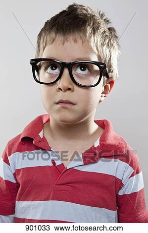 A young boy wearing fake glasses looking up, studio shot View Large Photo Image Stock Image - A young boy wearing fake glasses looking up, studio shot. Fotosearch