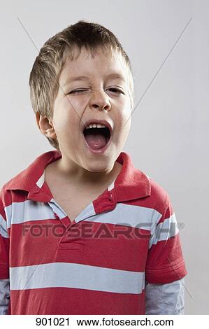 A young boy winking mischievously, studio shot View Large Photo Image Stock Image - A young boy winking mischievously, studio shot. Fotosearch