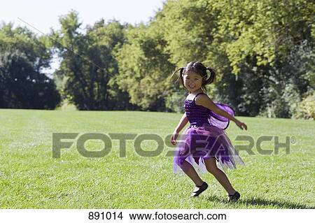 A young girl in a fairy costume running in a back yard View Large Photo Image Picture - A young girl in a fairy costume running in a back yard. Fotosearch
