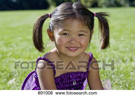 A young girl sitting on grass View Large Photo Image Stock Photo - A young girl sitting on grass. Fotosearch